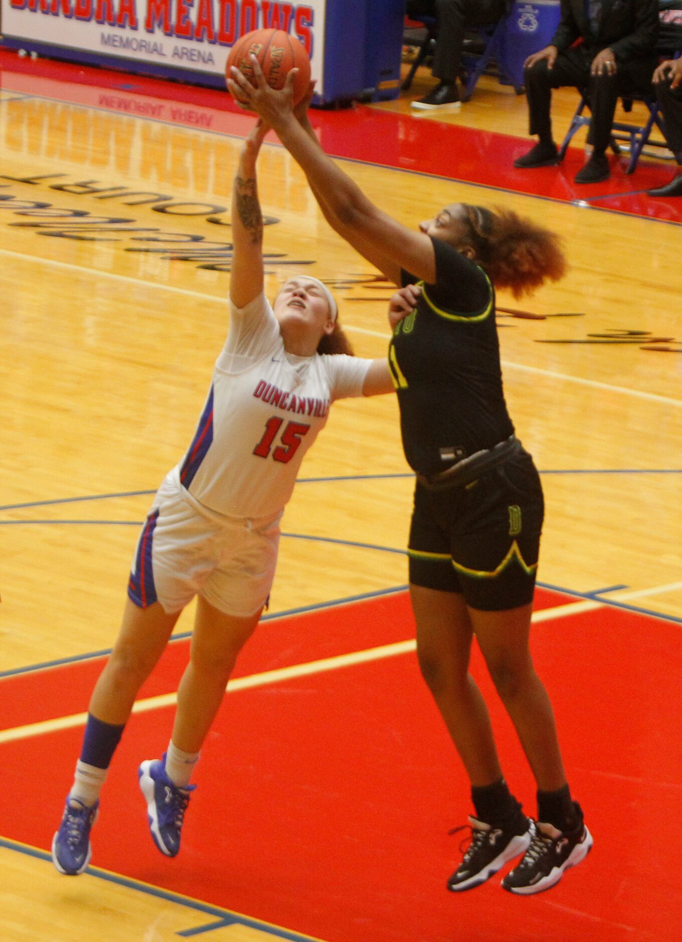 DeSoto's Tionna Herron (11), right, leaps over Duncanville's Tajenae Gooden (15) to pull in...