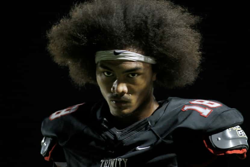 Euless Trinity receiver Keanu Hill (18) walks to the team bench following an incomplete pass...