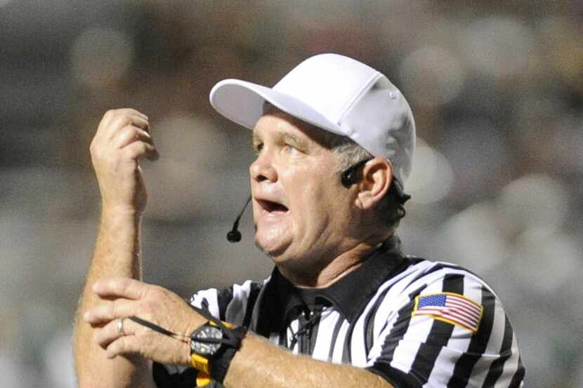 A referee makes a penalty call during Class 5A high school football game between Arlington...