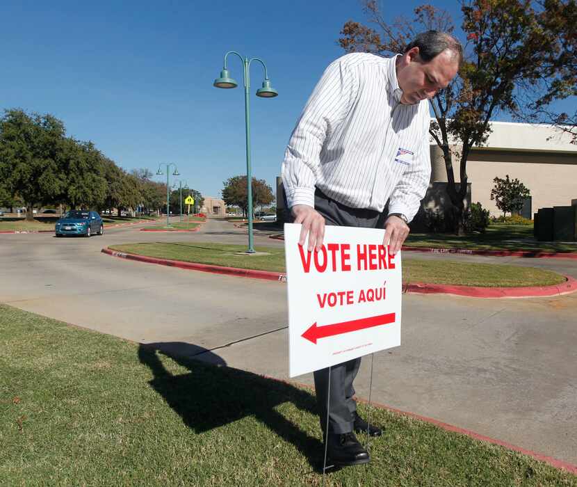 Election Clerk Warren Tyson posts polling place signs Tuesday morning outside the Euless...