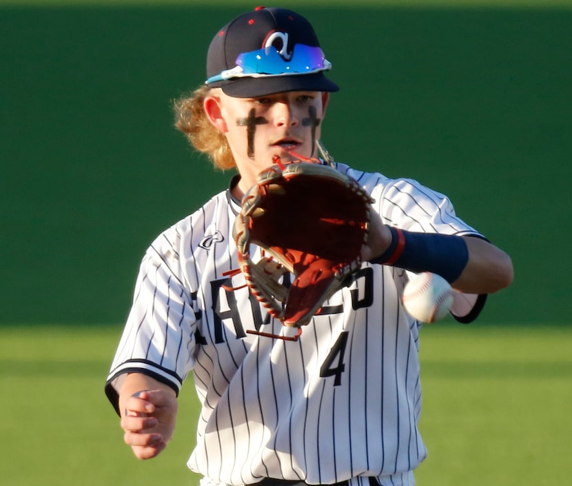 Allen High School third baseman Brady Coe (4) fields a high chopping grounder in the first...