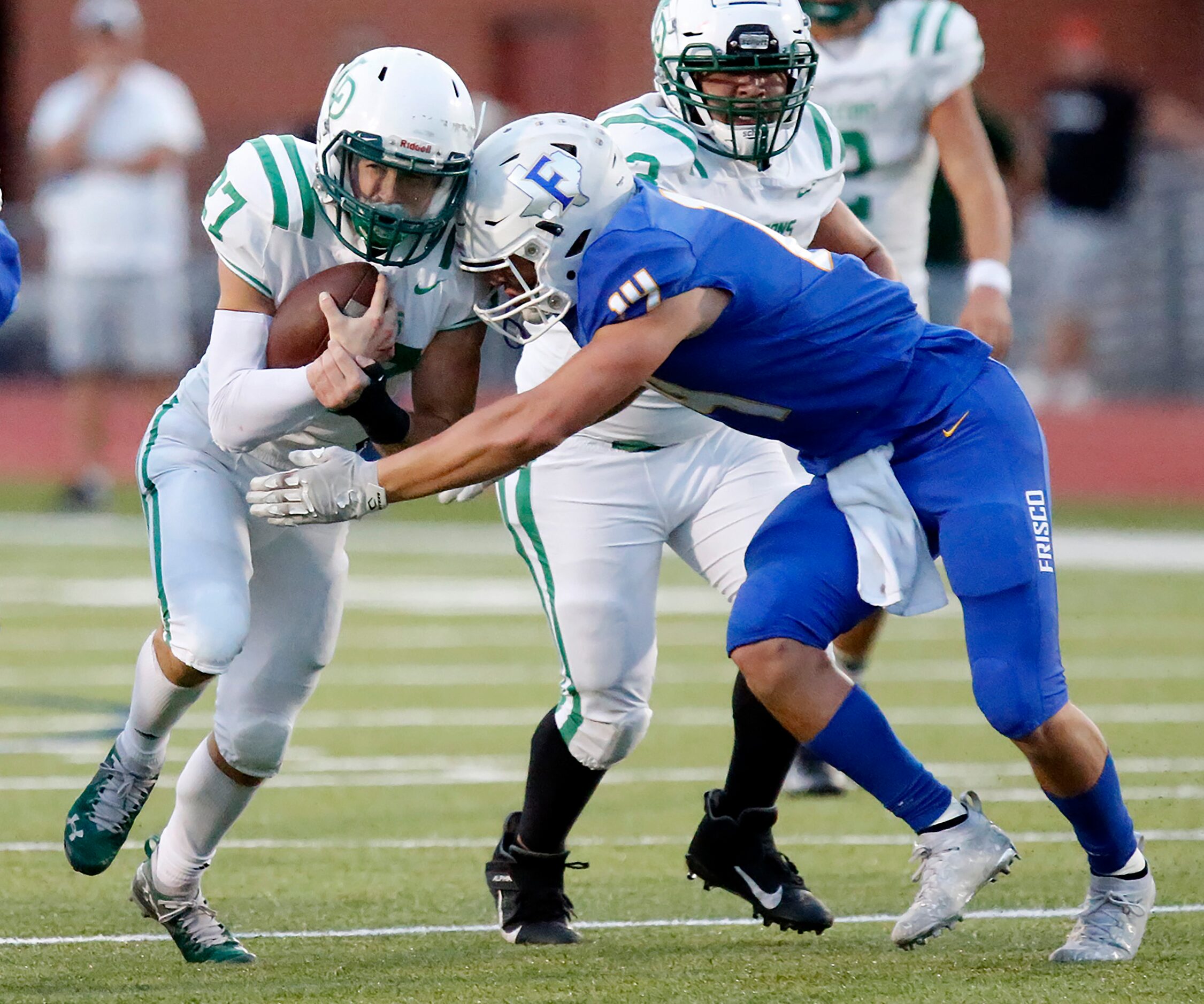 Lake Dallas High School running back Drew Mckinney (27) is met by Frisco High School...