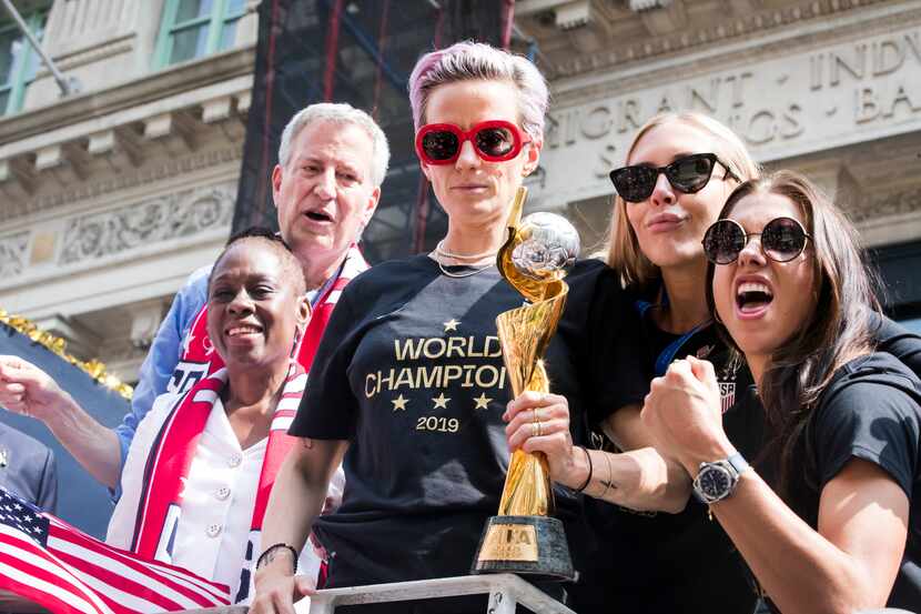 Megan Rapinoe sostiene el trofeo  de campeón que ganó junto con la selección femenil de...