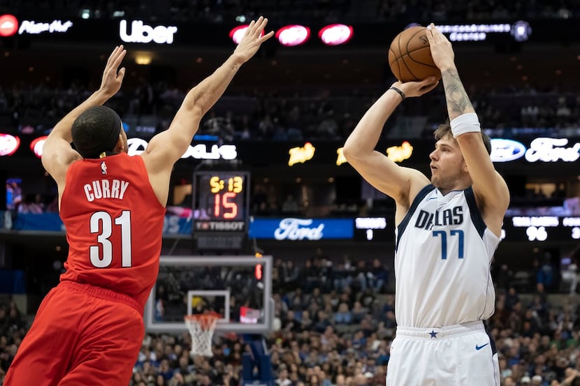 Dallas Mavericks forward Luka Doncic (77) shoots over Portland Trail Blazers guard Seth...
