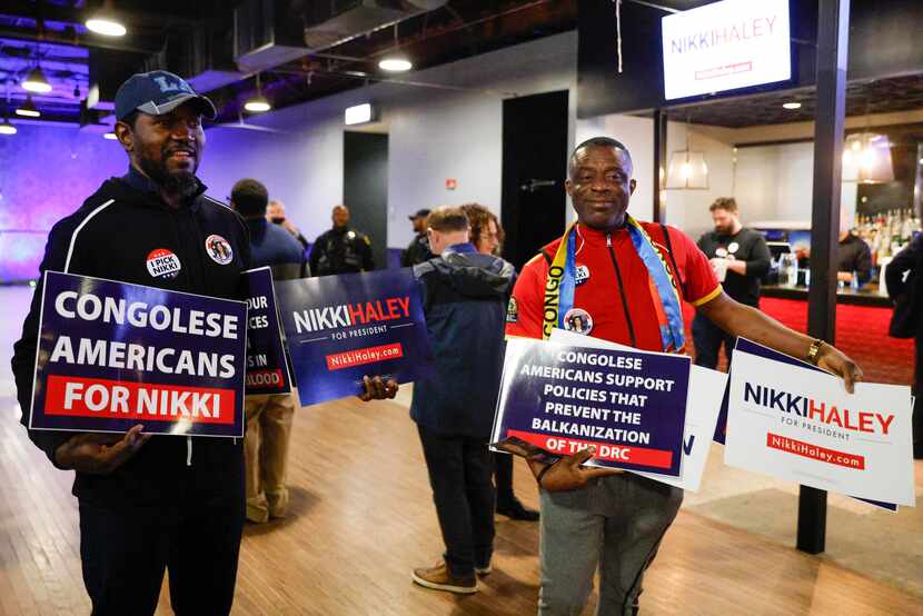Patrick Mwamba of Fort Worth (left) and Jean Marie Tshiunza of Euless hold signs supporting...
