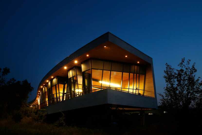 Tall, glass windows of the Trinity River Audubon Center house an art gallery and...