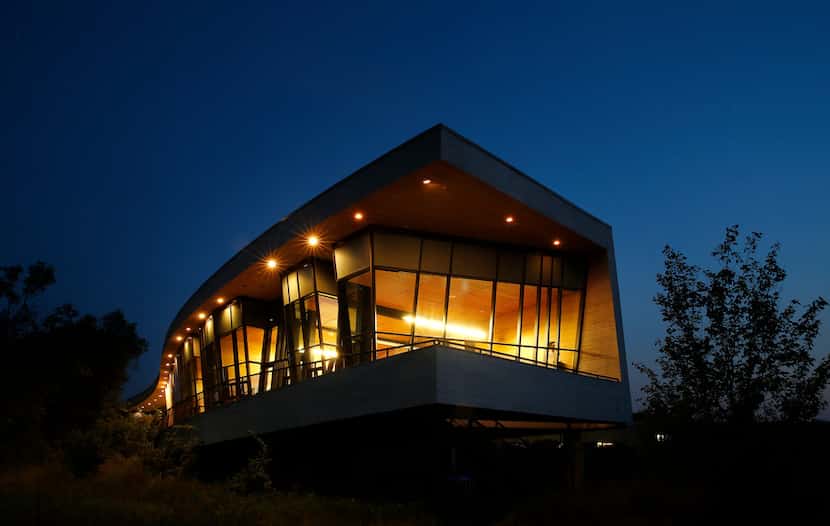 Tall, glass windows of the Trinity River Audubon Center house an art gallery and...