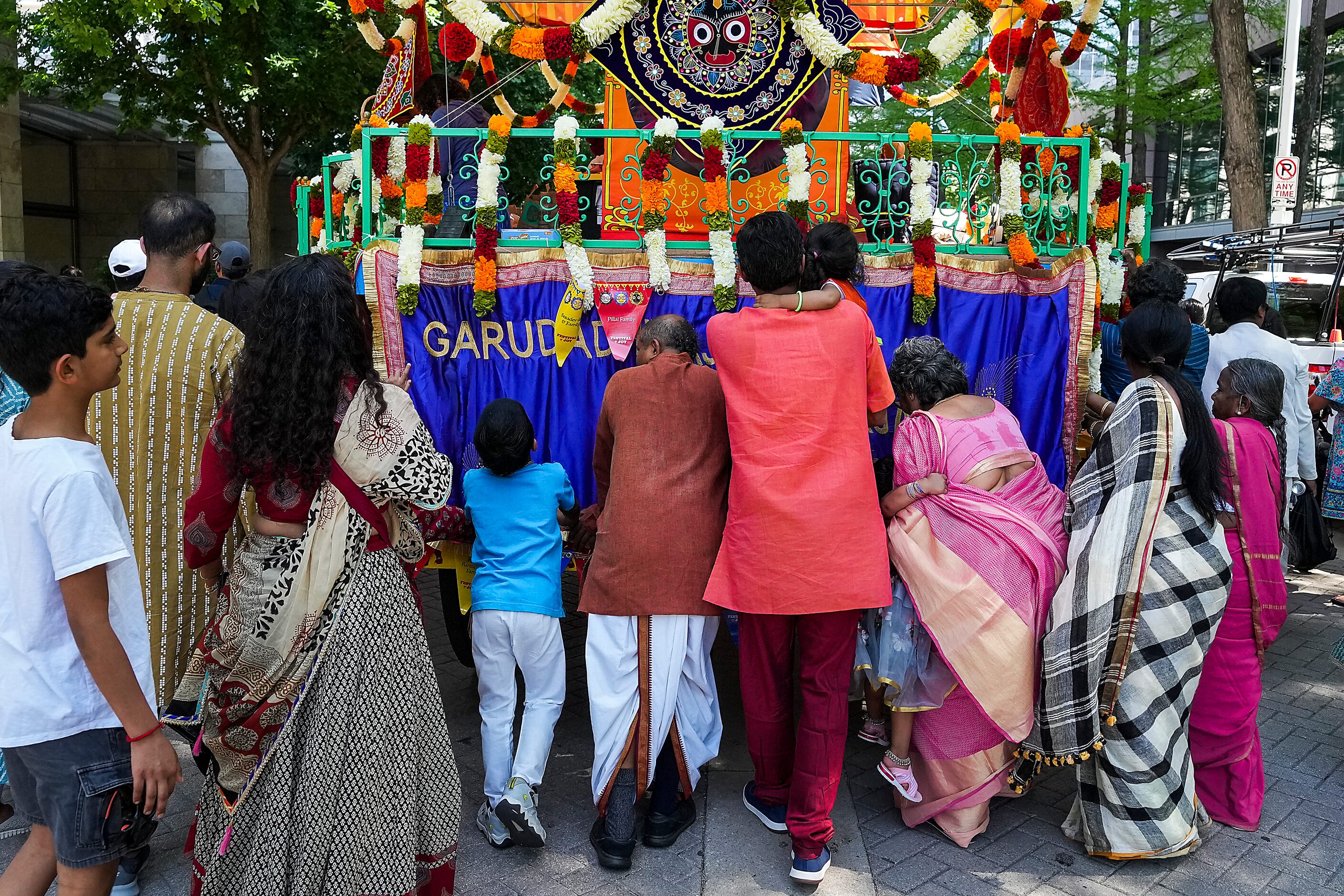 Devotees help push chariot along Flora Street as part of the Ratha Yatra parade during the...