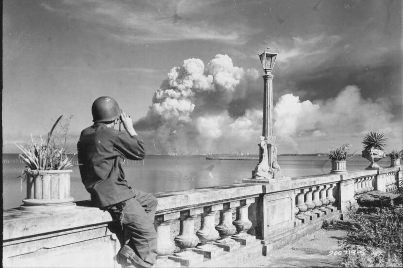 An American soldier watches Manila burn from the beach at Paranque on Feb. 8, 1945. From...