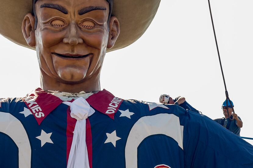 Crews remove one of the steel cables used to lift Big Tex at The State Fair of Texas in...