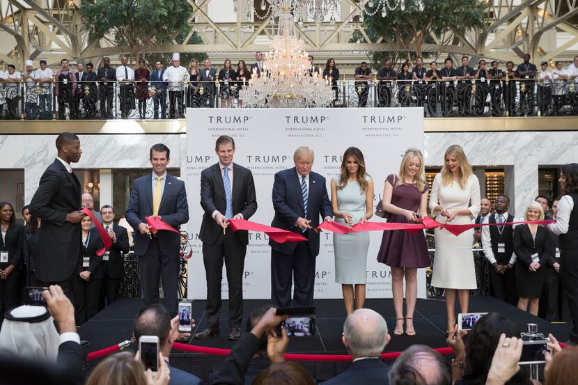 Donald Trump, center, cuts the ribbon with his wife and children during the opening ceremony...