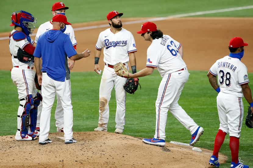 Texas Rangers relief pitcher Ian Gibaut (63) reaches for the ball as he comes in to relieve...