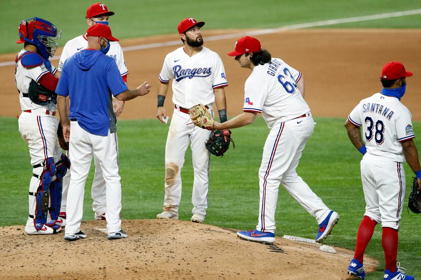 Texas Rangers relief pitcher Ian Gibaut (63) reaches for the ball as he comes in to relieve...