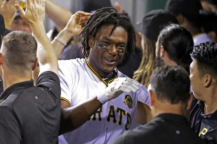 Pittsburgh Pirates' Josh Bell, center, is mobbed by teammates in the dugout after hitting a...