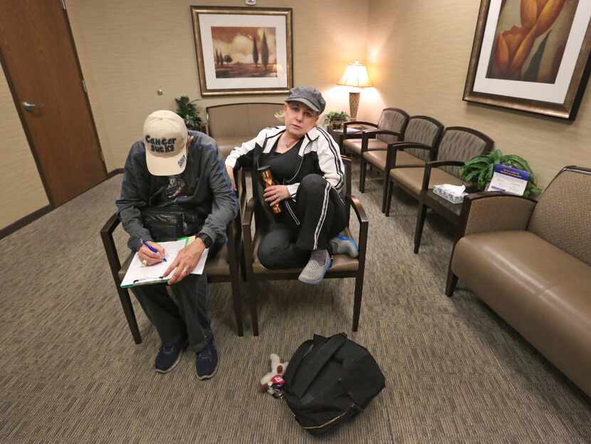 Marni Weiss looks on as her husband Jeffrey Weiss fills out paperwork at Baylor University...