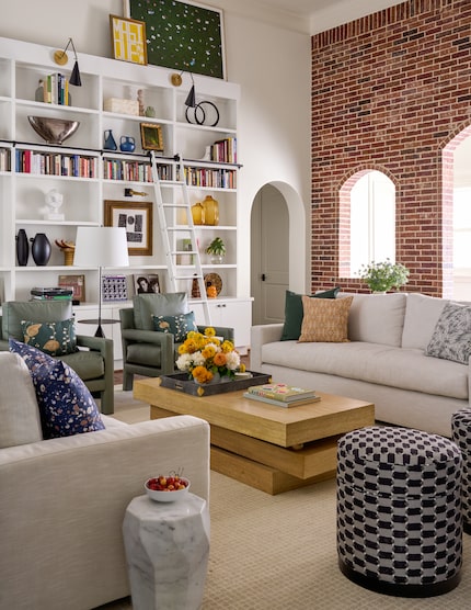 Living room with built-in bookshelf and cabinetry plus chairs and sofas for conversation, a...