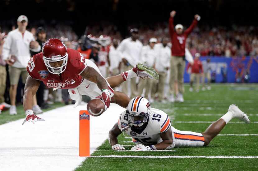 Joe Mixon #25 of the Oklahoma Sooners scores a touchdown over Joshua Holsey #15 of the...