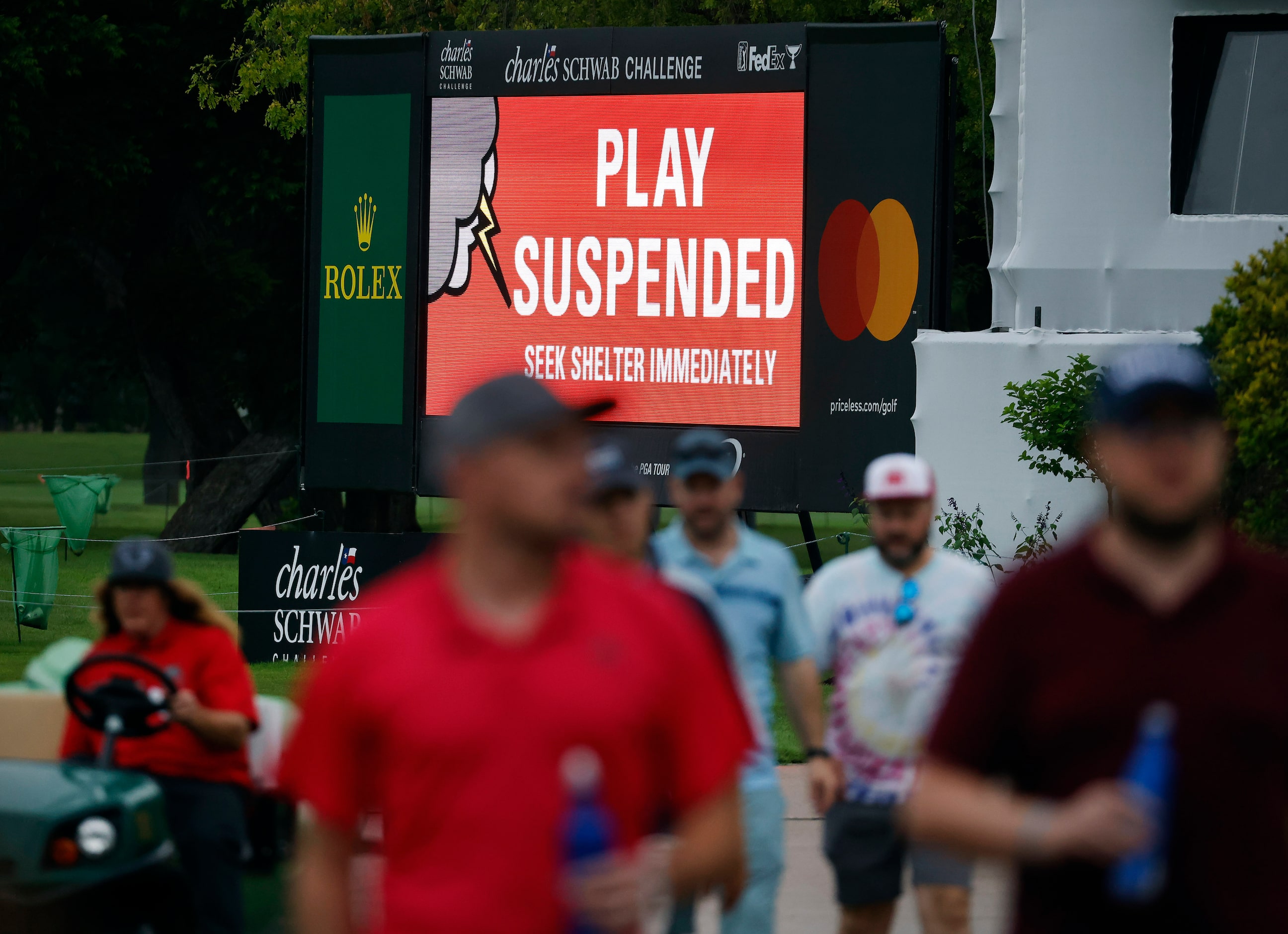 Fans head for shelter after golf was suspended to rain and lightning during round two of the...