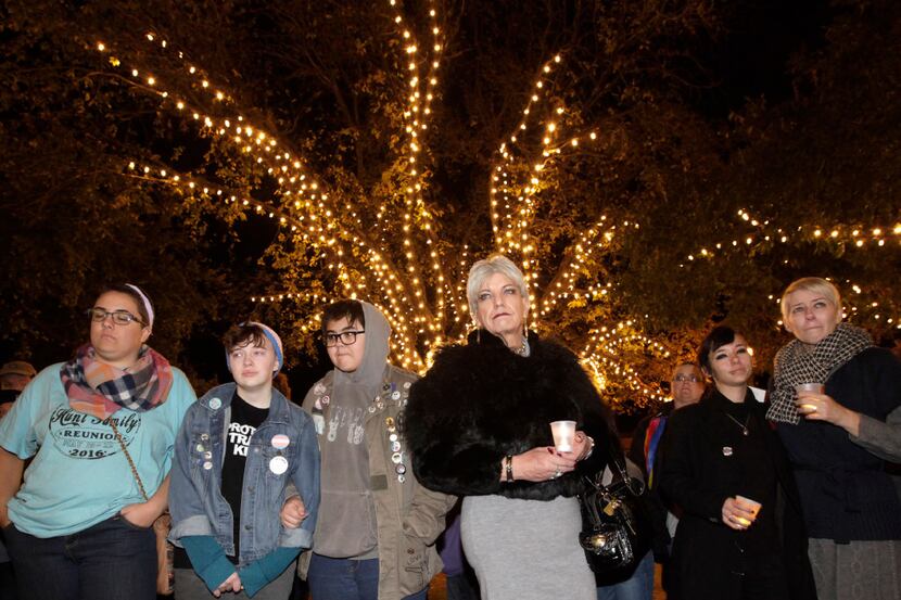 People gather to hold a Transgender Day of Remembrance event at the town square in Denton,...