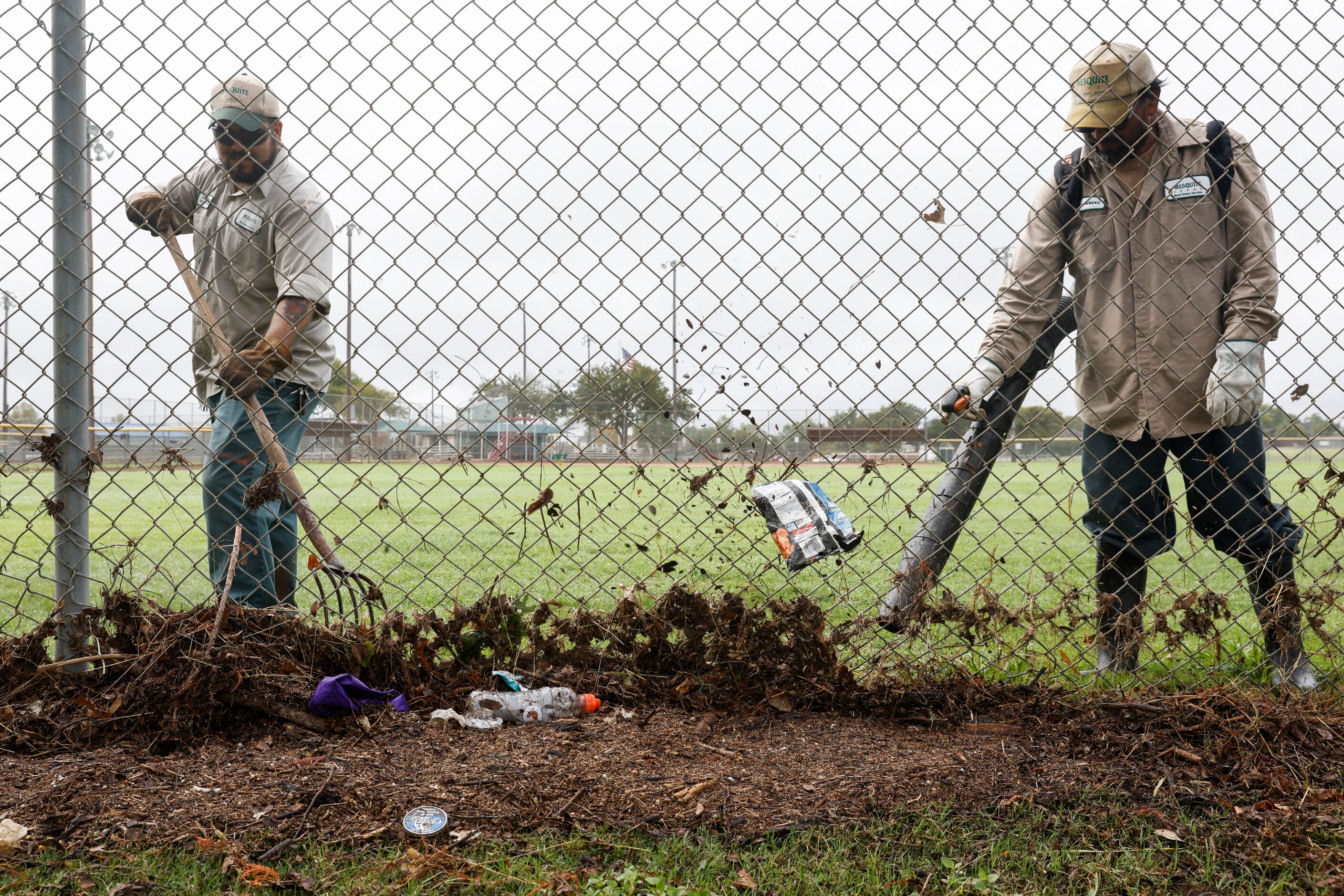 Mesquite Parks and Recreation Department employees Alejandro, right, and Abraham blow off...