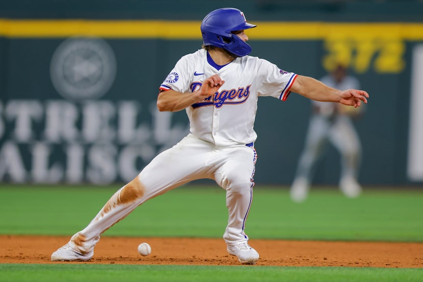 Texas Rangers' Josh Smith runs back to second base, avoiding a ground ball from Robbie...