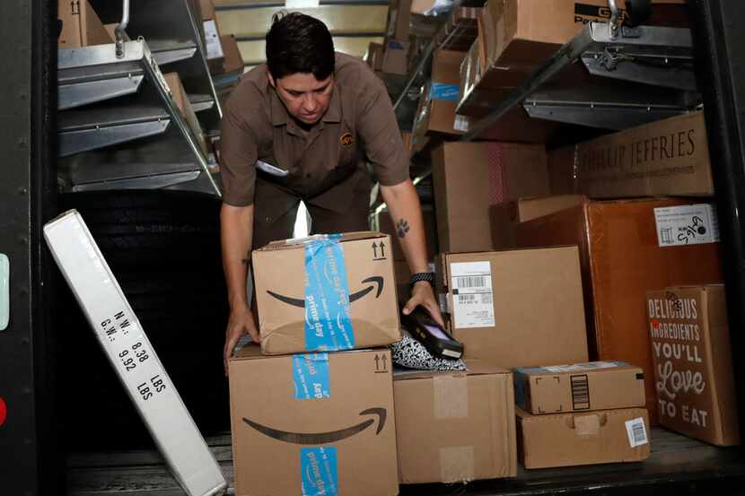 In this 2018 file photo, UPS employee Liz Perez unloads packages for delivery in Miami. 