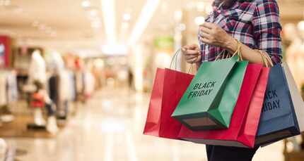 Foto de una mujer con bolsas de compras que dicen "Black Friday".
