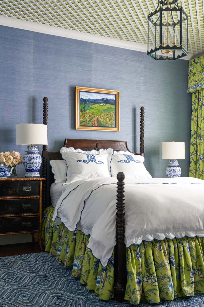Bedroom with blue grasscloth wallpaper, white bed linens, an antique nightstand and a bright...