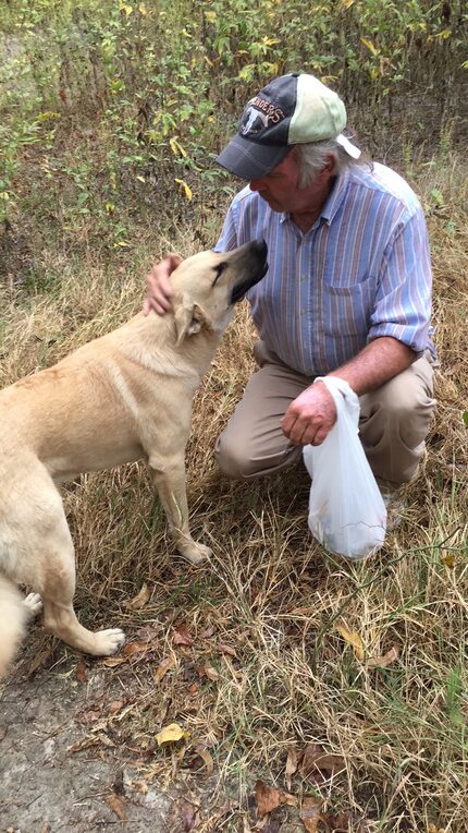 Charles pets his dog, Sid.