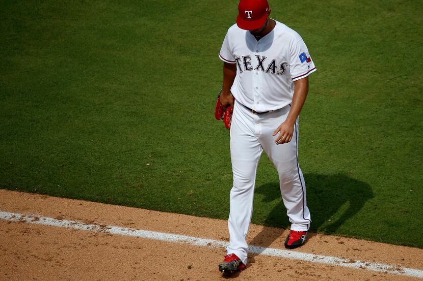 Texas Rangers starting pitcher Yu Darvish walks off the field during the 8th inning against...