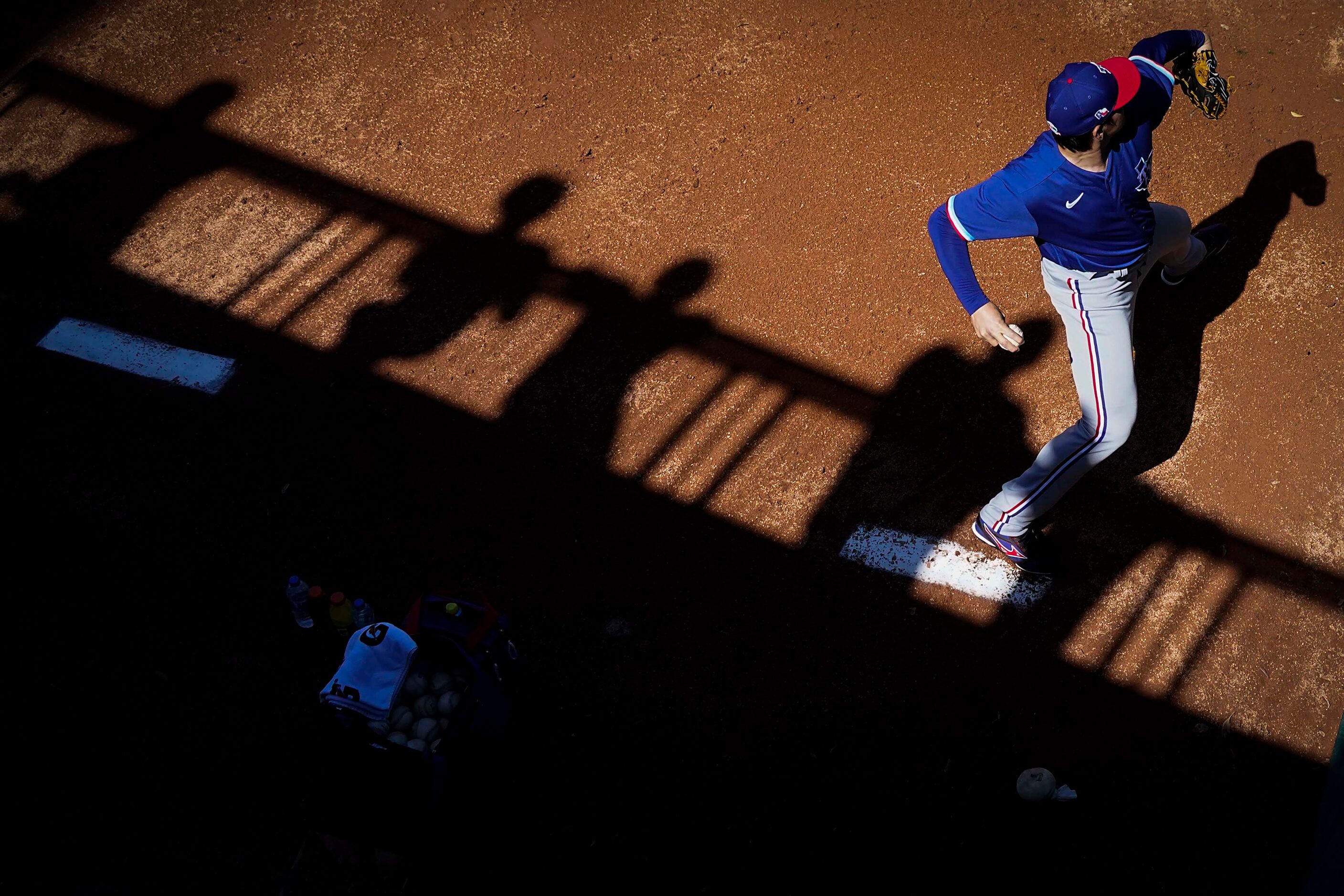 Texas Rangers pitcher Kohei Arihara warms up in the bullpen before a spring training game...