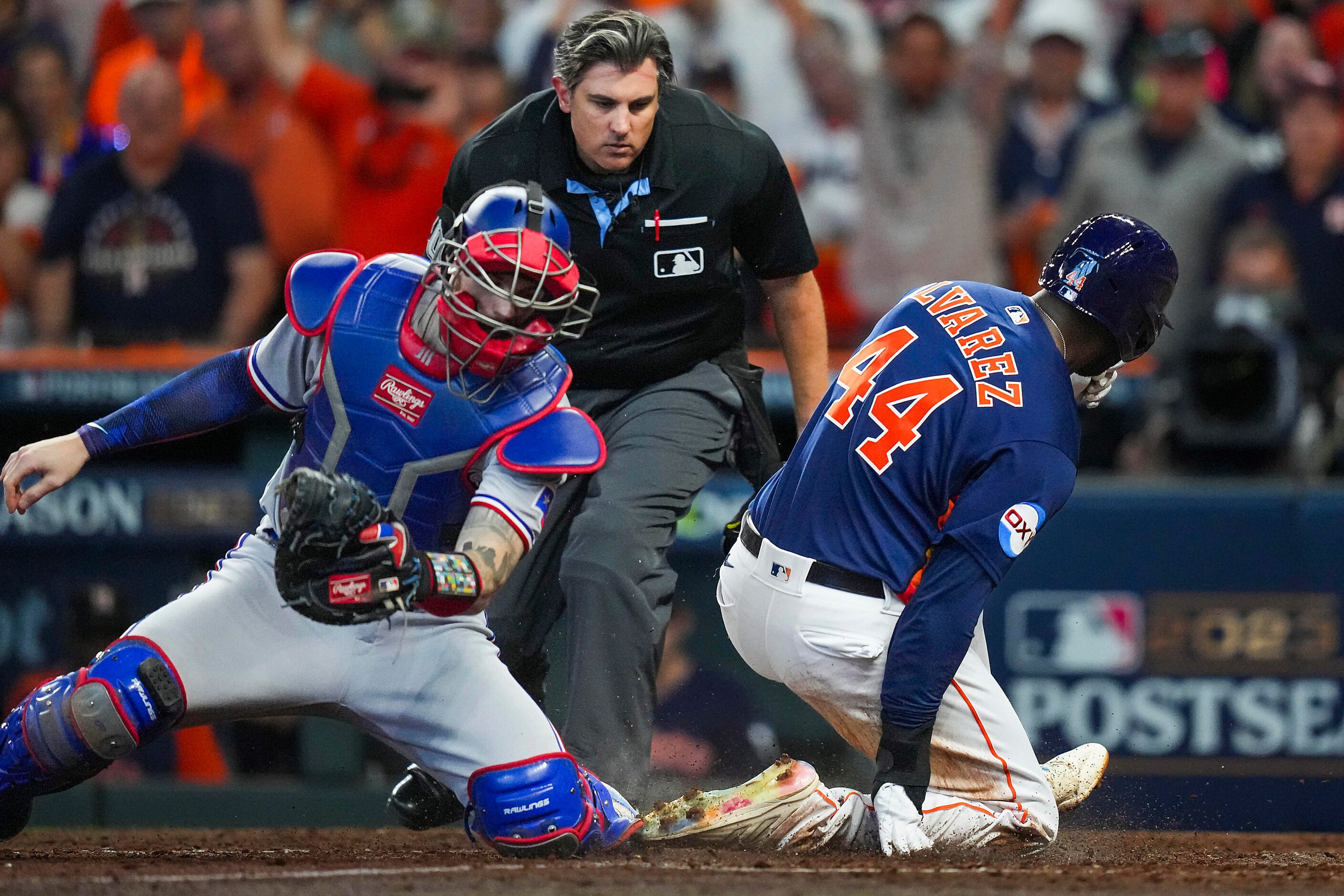 Houston Astros left fielder Yordan Alvarez scores past Texas Rangers catcher Jonah Heim...