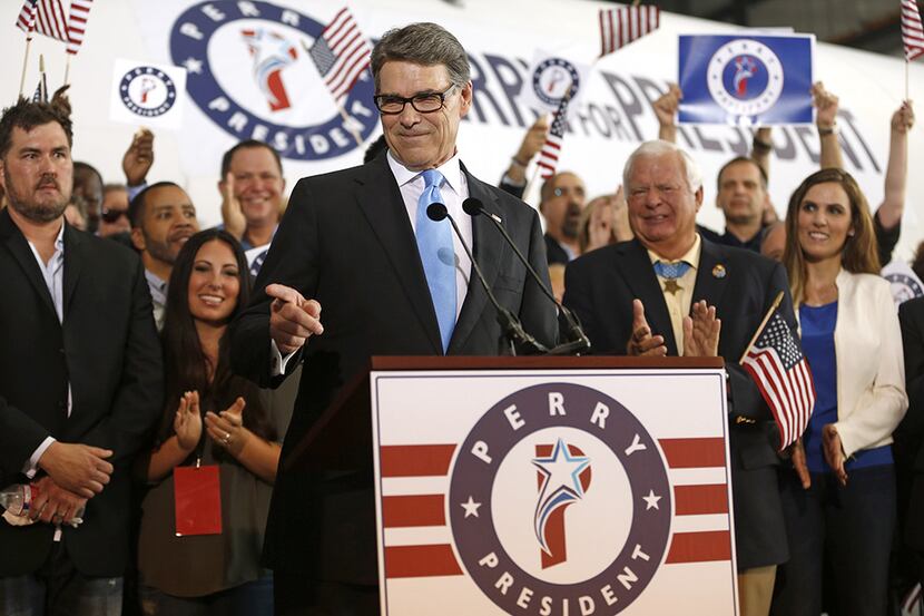 Former Texas Governor Rick Perry points to a supporter after announcing that he will run for...