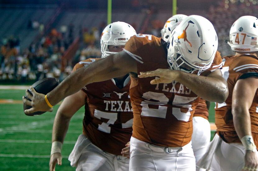 Texas running back Chris Warren III takes a bow after scoring his fourth touchdown, during...