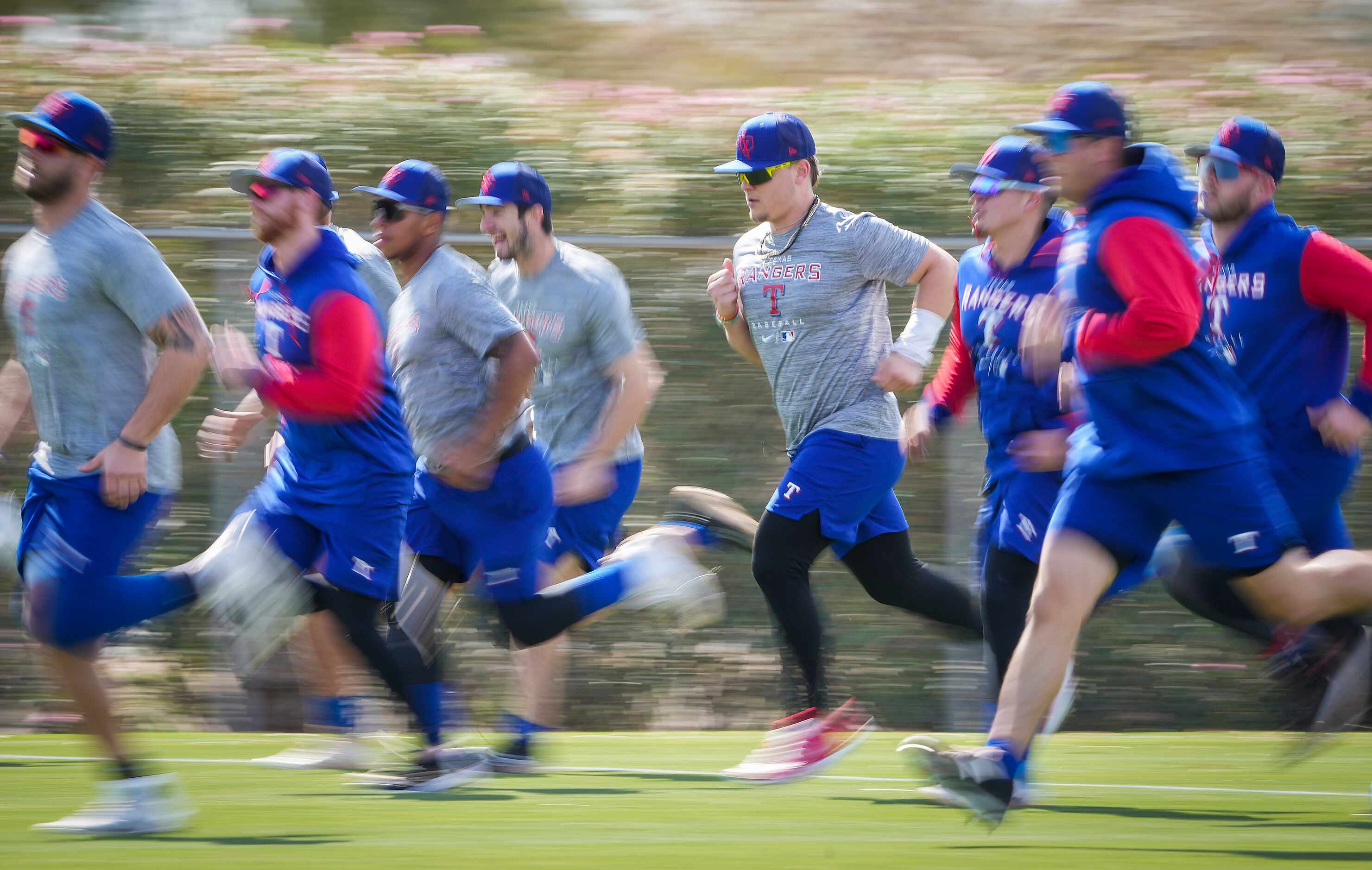 Texas Rangers minor leaguers, including outfielder Steele Walker (center) run on a...