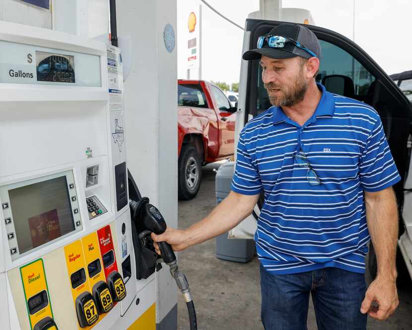 Jason Mullen, 49, returns the pump after filling up his truck Tuesday at a Shell station at...