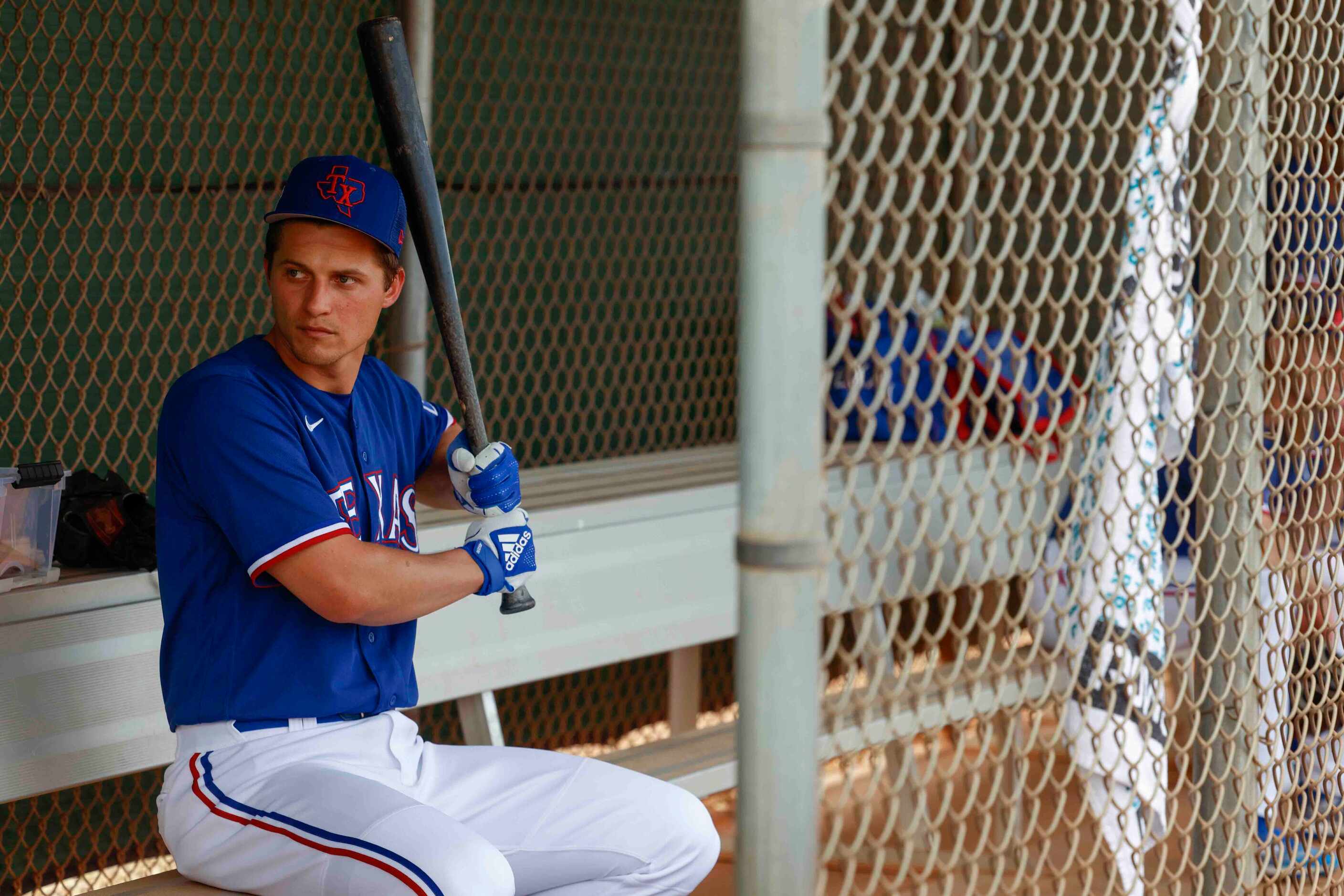 Texas Rangers infielder Corey Seager sits on the bench during a spring training workout at...