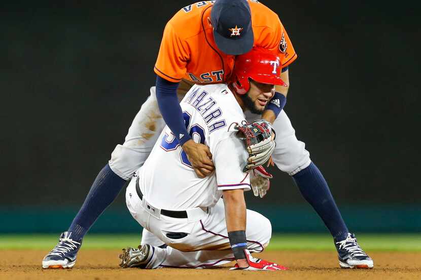 Houston Astros shortstop Carlos Correa (1) falls and hugs Texas Rangers runner Nomar Mazara...