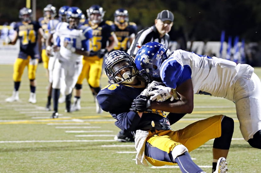 Highland Park's Cy McCullough (center) extends a leg out to make a game-winning touchdown as...