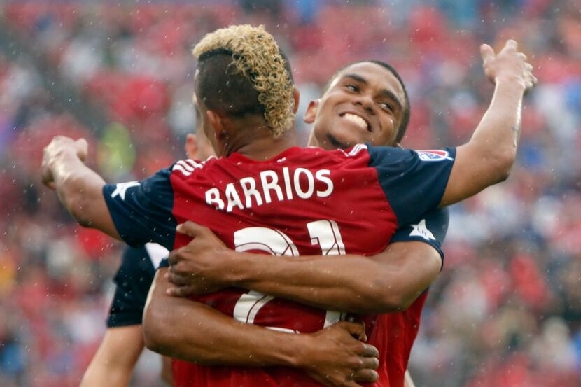 FC Dallas midfielder Michael Barrios (21) receives a congratulatory hug from defenseman...