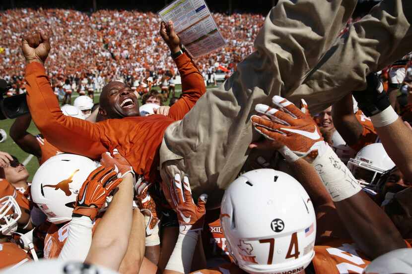 Texas Longhorns head coach Charlie Strong is lifted by his players after beating the...