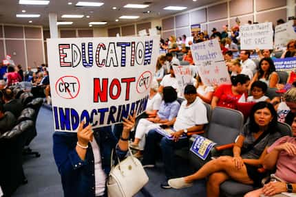 Protesters held signs Tuesday before the FWISD board meeting in Fort Worth. (Juan...
