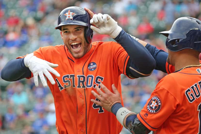 Houston Astros center fielder George Springer (4) is all smiles as he is congratulated by...