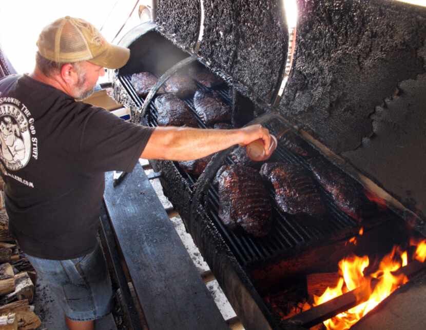 Pitmaster Robert Reid tends to the ribs on the smoker at Miller's Smokehouse in Belton. Ribs...