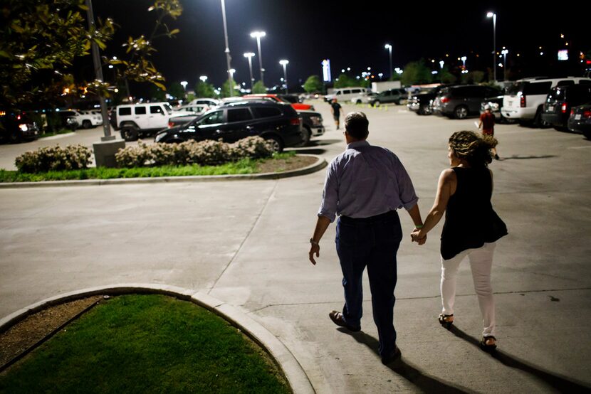 Meryl Evans holds hands with her husband, Paul Evans, as they leave a concert.