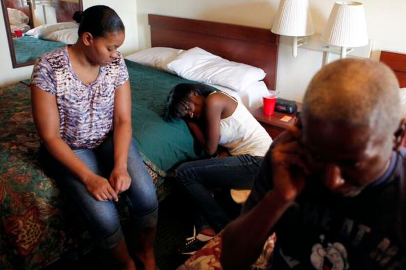 Dwayne Hill, 43, talks on the phone while his wife, Denice Collier, 37, (far left) and...