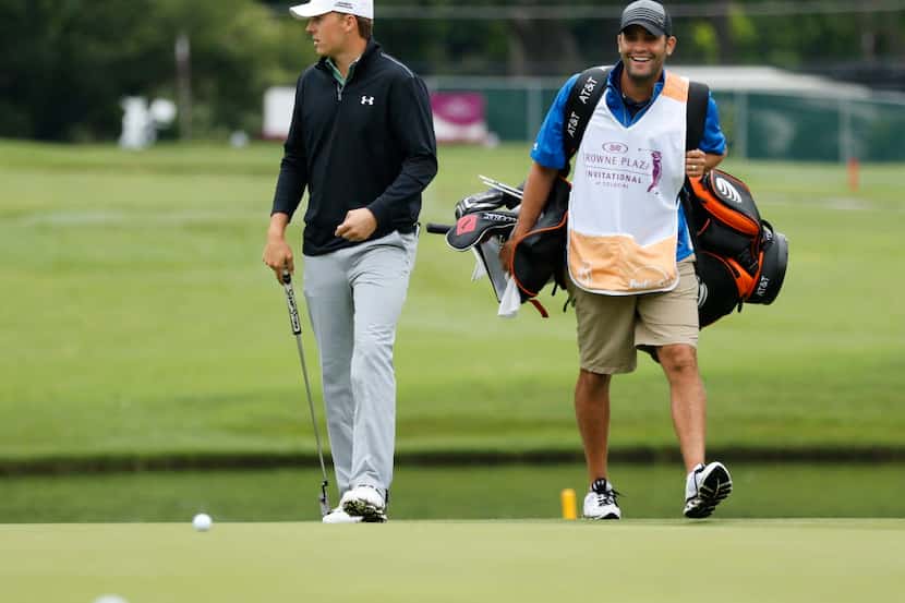 Jordan Spieth and his caddy Michael Greller walk up to the putting green on the sixteenth...