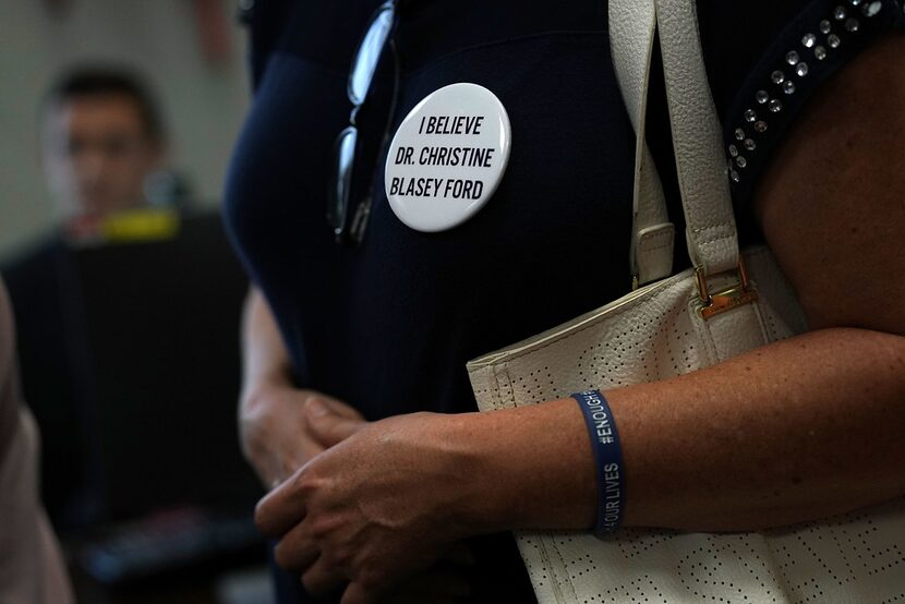 An activists wears a button in support of Christine Blasey Ford, who has accused Supreme...