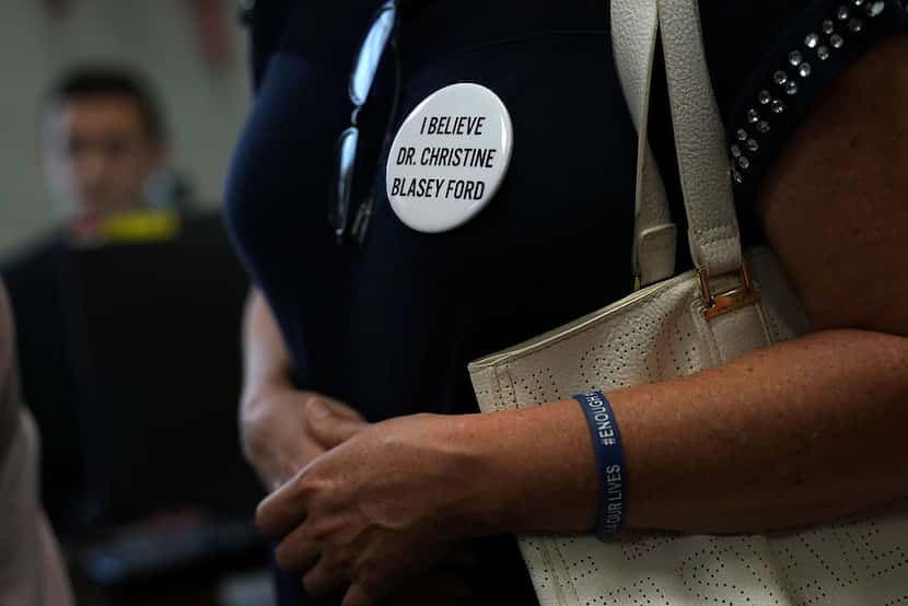 An activists wears a button in support of Christine Blasey Ford, who has accused Supreme...