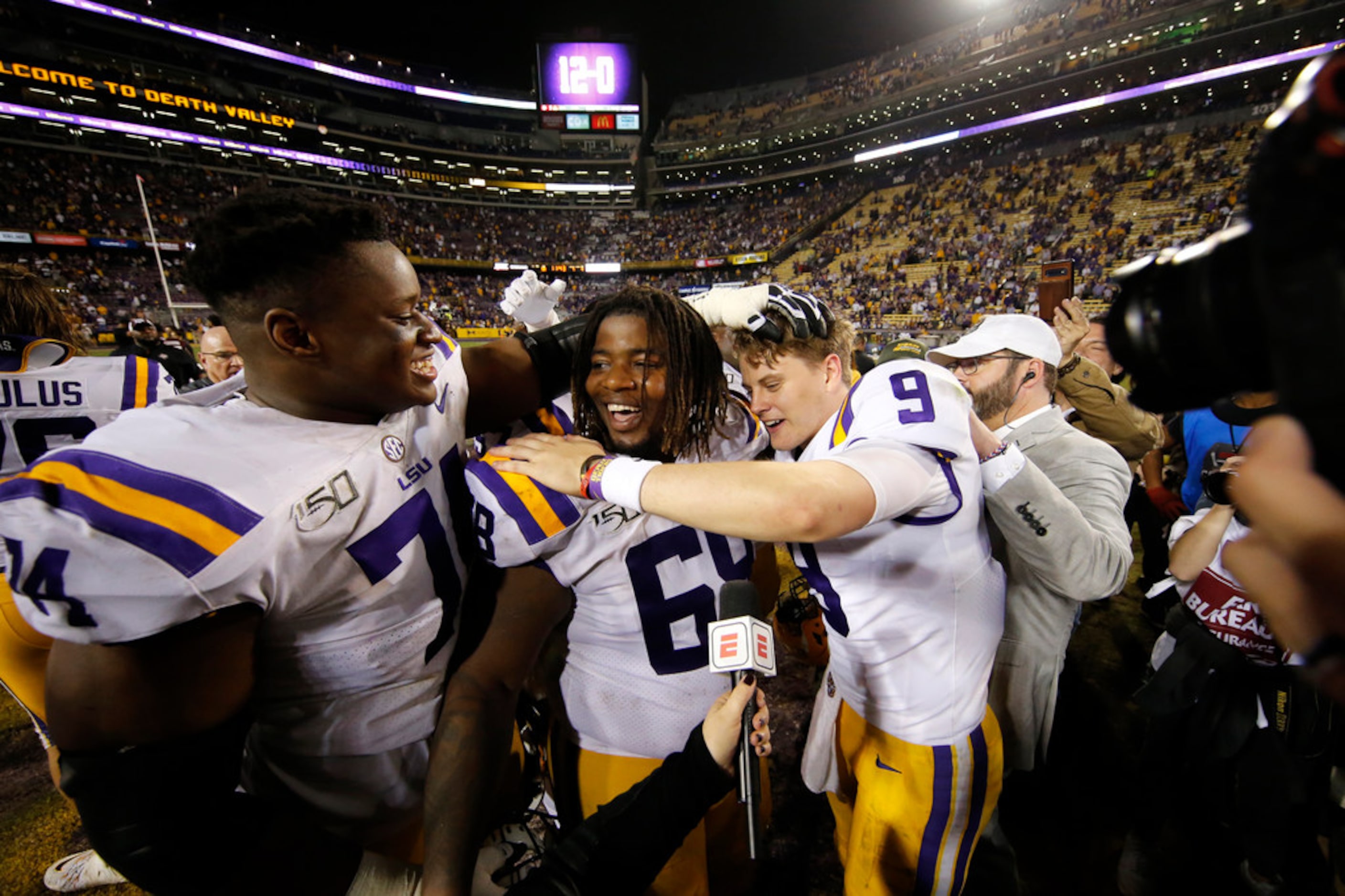 LSU quarterback Joe Burrow (9) celebrates with guard Damien Lewis and offensive tackle...